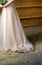 Bride in wedding dress in a barn waiting groom.