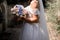 Bride in wedding dress and bouquet in park