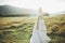 Bride in wedding dress posing on grass with beautiful landscape background