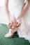 Bride in a wedding dress puts shoes on her feet