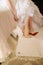 Bride in a wedding dress puts shoes on her feet