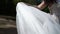 Bride in wedding dress waving cloth at wind