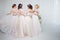 Bride in wedding salon. Four beautiful girl are in each other`s arms. Back, close-up lace skirts