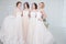 Bride in wedding salon. Four beautiful girl are in each other`s arms. Back, close-up lace skirts