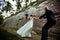 Bride whirls to a groom along a path behind an old stone wall