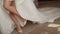 Bride in white dress and heels. Closeup of woman legs and feet. Female lifting her leg