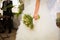 Bride in white dress hold wedding boquet in her hand