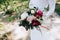 Bride in a white dress holding a beautiful Eucalyptus white pink and red peonies wedding bouquet in her hands