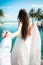 bride in white dress holding groom in luxury resort. Romantic woman leading man to swimming pool.