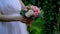 Bride in white dress holds in her hands beautiful delicate wedding bouquet