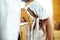 Bride in a white shawl prays before a priest standing on the knees