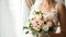 a bride in a white wedding dress, captured in a close-up image, with a delicate bouquet of flowers, standing by the