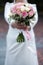 The bride in a white wedding dress is holding a bouquet of white flowers - peonies, roses. Wedding. Bride and groom. Delicate