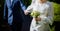 The bride in a white wedding dress is holding a bouquet of white flowers - peonies, roses. Wedding. Bride and groom. Delicate