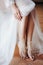 Bride in white wedding dress opened bare feet. Close up