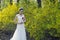 A bride with white wedding dress stand by Golden jasmine flowers