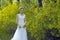 A bride with white wedding dress stand by Golden jasmine flowers