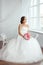 The Bride. Young women with wedding dress in very bright room,