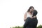 Bridegroom lifting bride while standing against clear sky in park