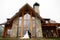 Brides morning. A woman in a wedding dress and a man in a stylish suit stand in front of a gorgeous house in the mountains