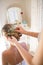 Bridesmaid adjusting bride hair in dressing room