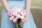 Bridesmaid in blue dress hold bouquet with white and pink peony