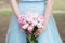 Bridesmaid in blue dress hold bouquet with white and pink peony