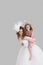 Bridesmaid getting a piggyback ride from young bride over gray background