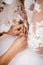 Bridesmaid helps bride to put on a wedding dress.