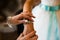 Bridesmaid helps to tie a bow on a festive white dress of the bride on the wedding day