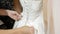 Bridesmaid helps zip up wedding dress