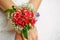 Bridesmaid in luxury wedding dress carries to delicate boutonniere with roses