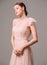Bridesmaid`s dresses. Elegant moscato dress. Beautiful pink chiffon evening gown. Studio portrait of young happy ginger woman. Tr