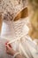 Bridesmaid tying wedding dress. lace wedding dress. charges of the bride