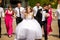 Bridesmaids and groomsmen look at a kissing wedding couple stand