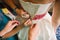 Bridesmaids hands lace up the dress on the back of the bride at the gathering on the wedding