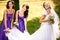 Bridesmaids help bride to put on earrings and necklace