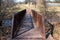 A bridge crosses a stream to a hiking trail through Pennsylvania countryside