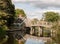 bridge crossing a river with reflections outside in country child and man on bridge