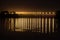Bridge on the dnieper river at night in the lights of lampposts at long exposure with reflection on the water