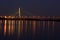 Bridge at night beside the Dnipro river with reflection in water