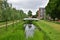 Bridge over a canal in the Netherlands, overgrown banks with reeds and rushes.