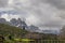 Bridge over the lake in lush green rural area with snowcap mountains in the background