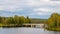 Bridge over the pond. A fabulous landscape of a Finnish lake in the midst of a dense Scandinavian green forest. The concept of