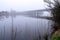 Bridge over river Corrib in Galway city, Ireland in a morning fog. Terryland castle in a mist in the background. Cool tone. Nobody