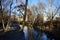 Bridge over the Wuhle River with the sun reflecting on the water. Berlin, Germany