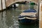 Bridge of red bricks above the channel. Boat on the water.