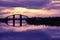 Bridge reflection in water surface of river Dnieper duaring sunset time.