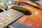 Bridge, soundhole and strings of a wooden classical guitar with shallow depth of field, close up