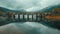 A bridge spans a river with a reflection of the bridge in the water